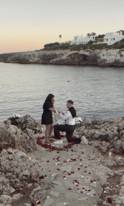 Christian on one knee, proposing by the water